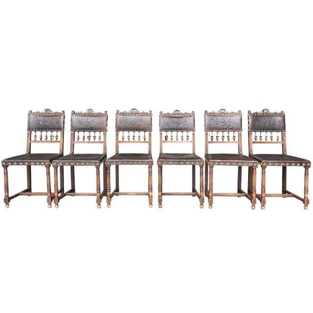 Set of six antique Spanish Revival dining chairs featuring richly embossed leather upholstery with floral and fruit...