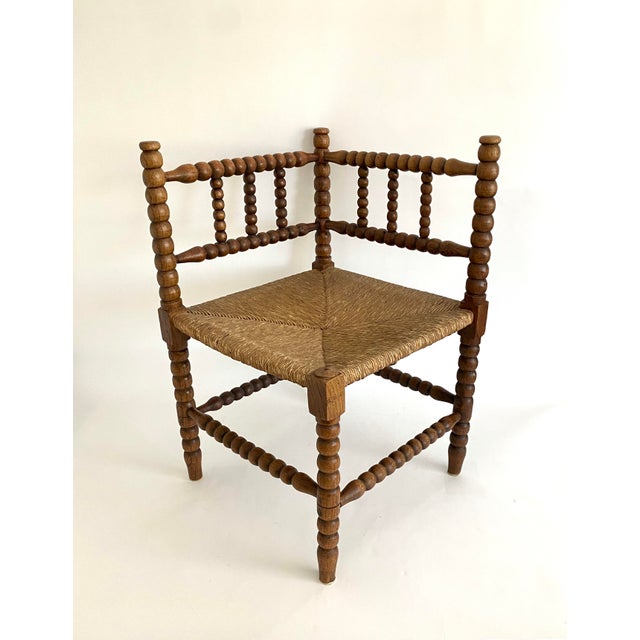 This early 1900s Dutch oak bobbin corner chair with rush seat has time earned patina. Hand-turned spindles are an example...