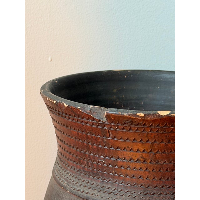 Handcrafted African earthenware vessel with geometric roulette, a rich burnished surface, and decades of authentic patina....