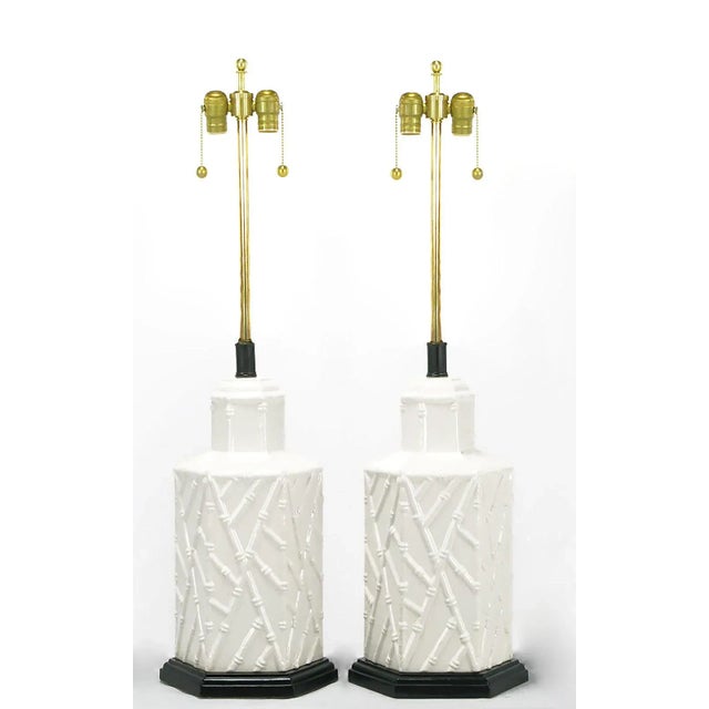 Pair of hexagonal shaped white ceramic bodied table lamps, with a patterned bamboo relief. Black lacquered and stepped...