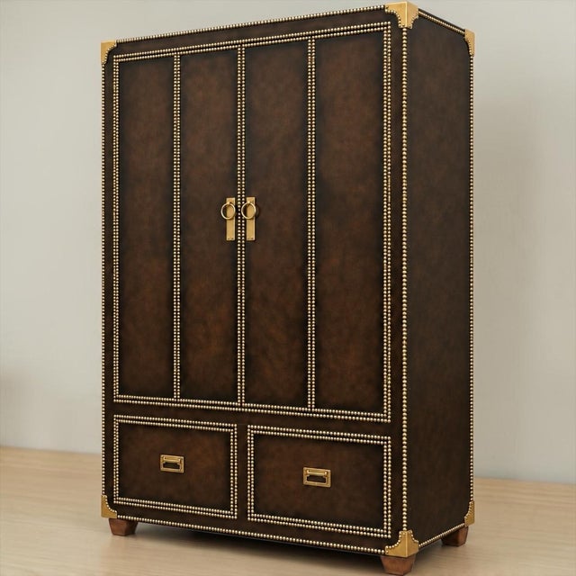 This is a regency campaign style leather and brass bar cabinet. It is completely framed in brass nailheads and has...