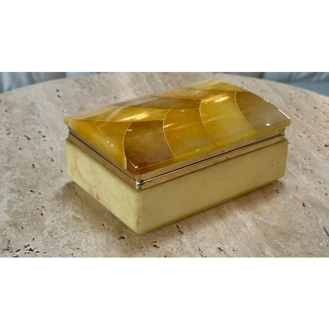 Elegant rectangular Italian decorative box crafted from translucent honey-toned marble, featuring a sculpted mosaic-...