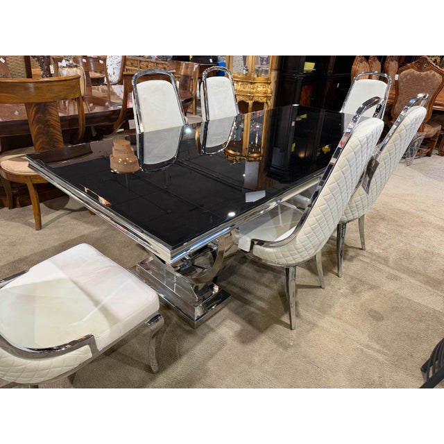 Sleek, modern, and effortlessly sophisticated, this Coaster dining set pairs a striking black glass tabletop with six...