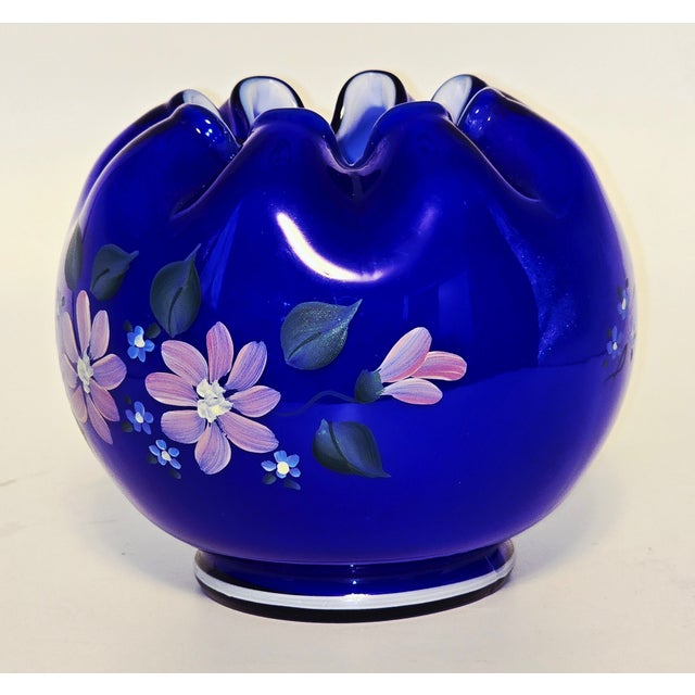 A striking example of Fenton Art Glass craftsmanship, this deep cobalt blue vase features a ruffled, scalloped rim and a...