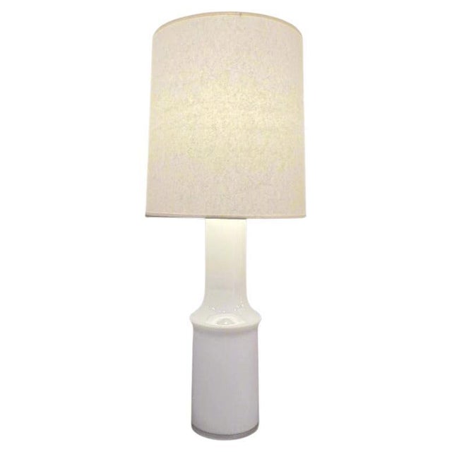 A single Modernist glass table lamp designed by Gert Nystrom for Hyllinge Glassworks. White cased glass with nickel...