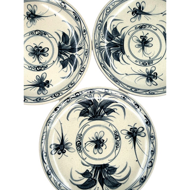 A striking set of six Bat Trang dessert plates featuring expressive cobalt blue dragonfly and botanical motifs against a...