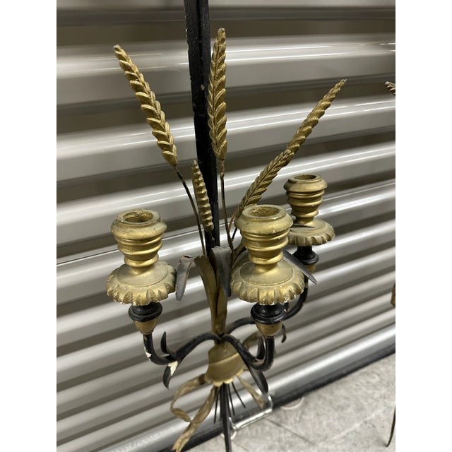 Pair of Italian candle wall sconces made of gilt wood and metal. They are designed as swords and are decorated with...