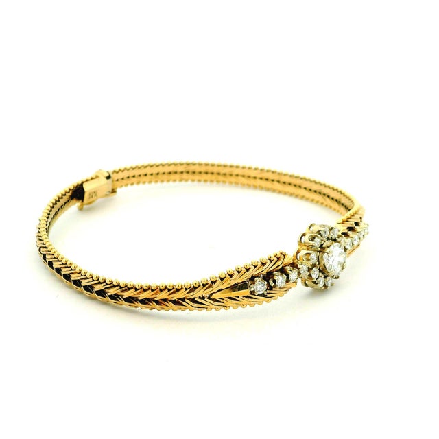 Crafted in Italy circa 1970, this elegant flexible bangle is beautifully made in 14 karat yellow gold and centered with...