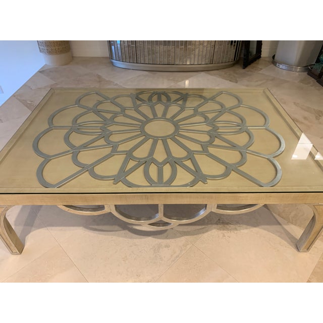 Super adorable beige and silver coffee table..This glass covered table has a unique flower design in the middle.. 2 years...