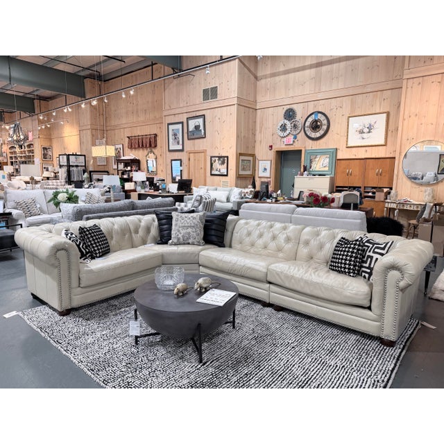 A grand Chesterfield-inspired sectional upholstered in supple ivory top-grain leather, bringing together the stately...