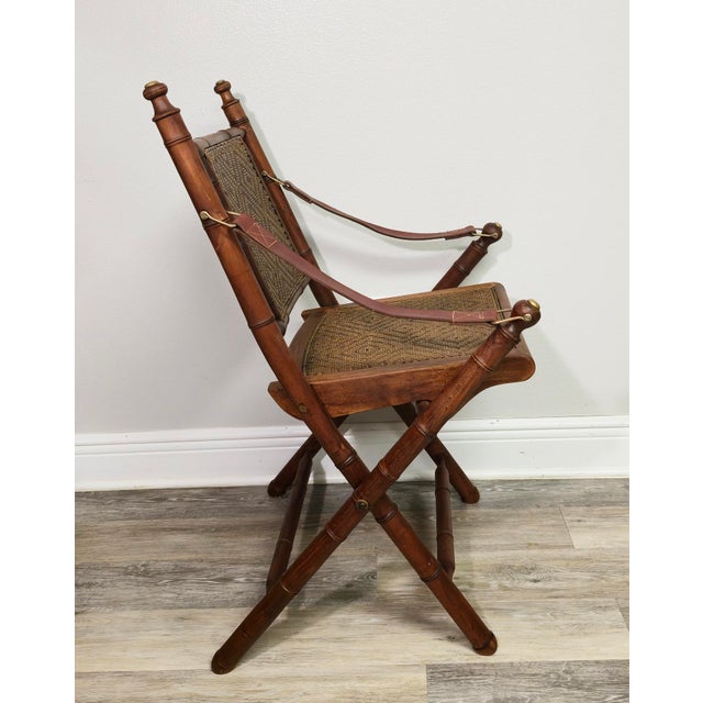 A pair of folding campaign chairs in faux bamboo hardwood — believed to be teak with original herringbone wicker seats and...