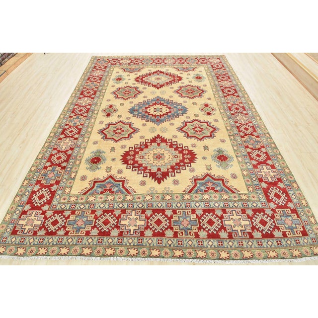 This traditional tribal geometric Caucasian Kazak rug is hand-knotted with an all-wool pile on a cotton foundation. This...