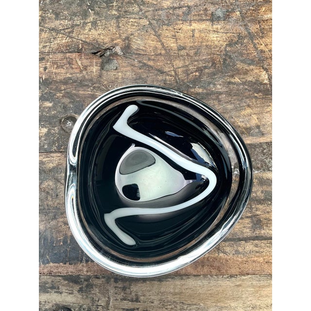 This exceptional signed Orrefors art glass bowl is a testament to the mid-century prowess of Swedish crystal design....