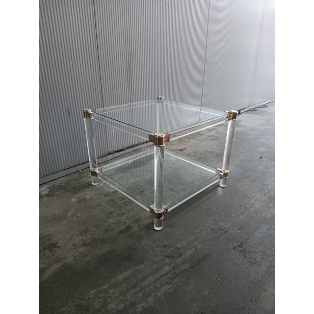 Elegant Hollywood Regency side table dating from the 1970s, executed in a refined combination of transparent acrylic glass...