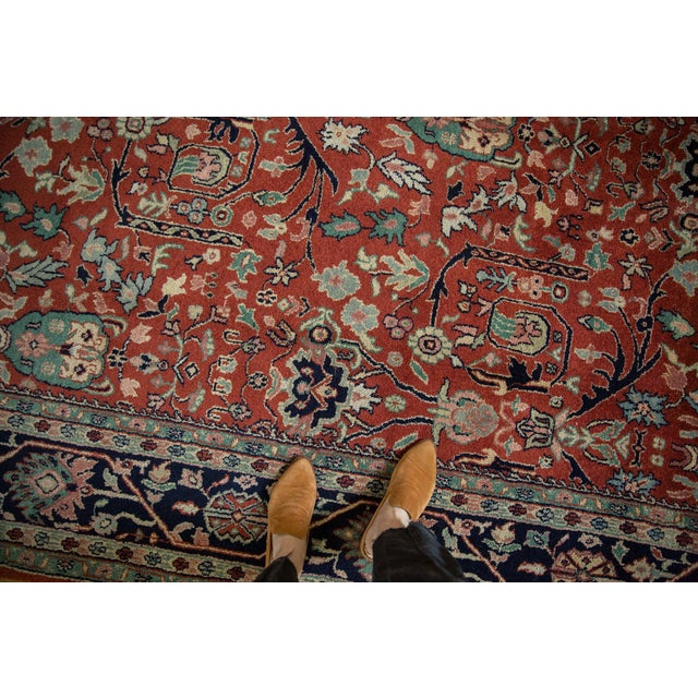 :: Allover covered field in a classic Bijar design bearing a gul ferang motif of scrolling rose floral elements and offset...