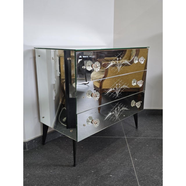 An elegant Venetian commode entirely clad in engraved mirrors, this piece combines refinement and luminosity in a...