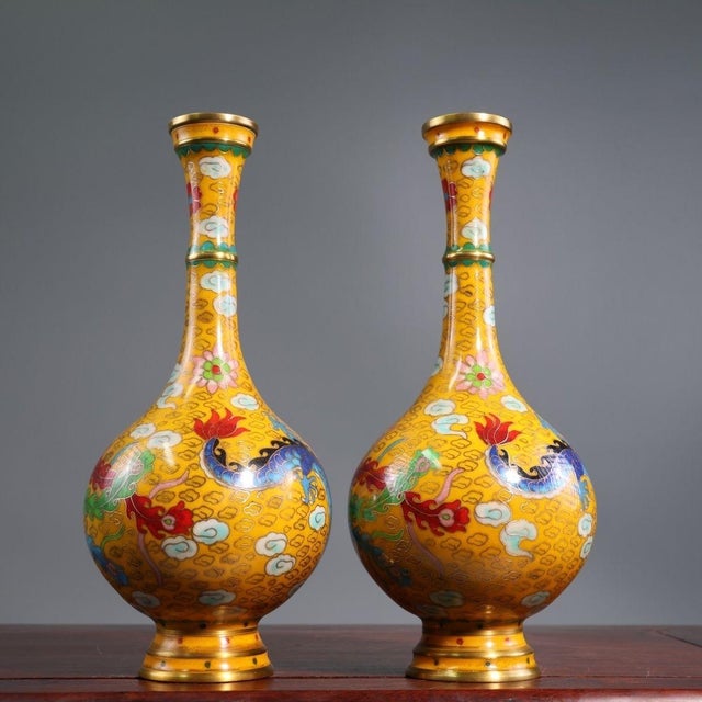 This is a striking and vibrant pair of matching cloisonné enamel vases. Featuring an elegant, elongated bottle form with a...