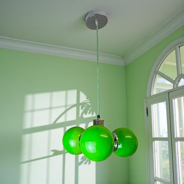 Amazing chandelier from the 1960s, made of chromed metal and glass ball lampshades. The chandelier is equipped with three...