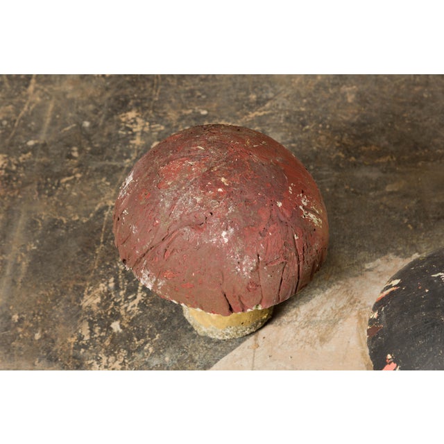 A set of three American Midcentury painted concrete mushroom garden ornaments with red and black tops and nicely weathered...