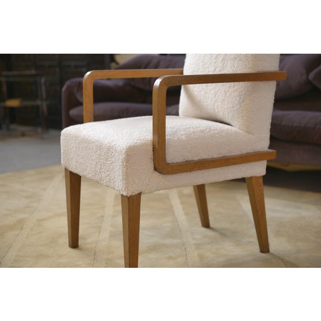 Armchair with modernist lines, featuring a wooden frame with straight armrests that create a continuous silhouette. The...