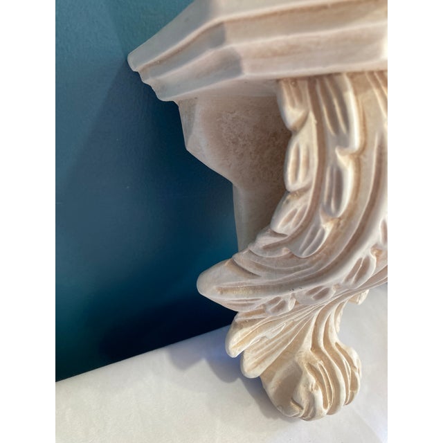 This vintage pair of wall-mounted shelves are designed in the style of classical architectural corbels. The deeply carved...