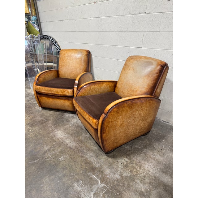 Amazing pair of art deco style leather club chairs with reversible velvet cushion. One side is leather and the other is...