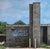 This artwork presents a detailed portrayal of an abandoned building, its weathered façade adorned with vibrant graffiti....