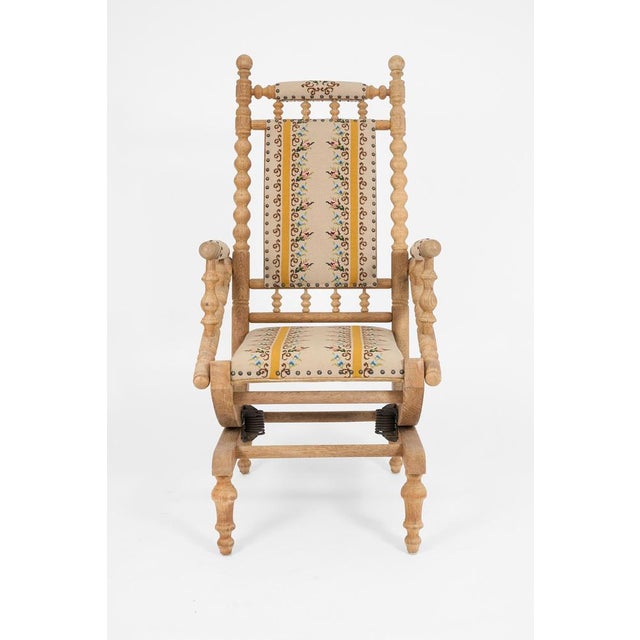 Decorative Scandinavian rocking chair crafted in solid oak with turned details and floral woven upholstery. A charming...