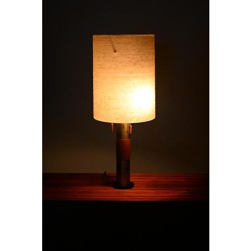 Table lamp with teak and brass. The shade is made from glass fibre. This large lamp has 2 fittings (e27) which can be...