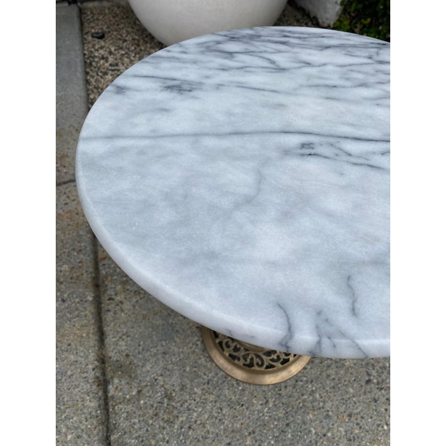 Vintage side table with a round marble top and pierced brass pedestal base. Suitable for use as a side table or accent...