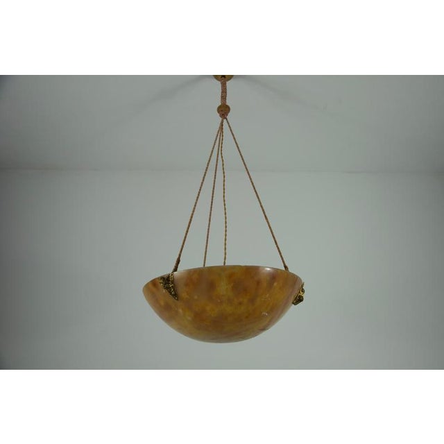 This large and heavy hand-carved alabaster ceiling lamp was crafted in germany during the 1930s and is a striking example...