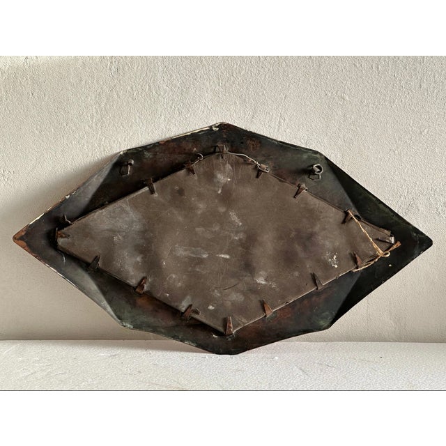 A distinctive hand-hammered copper wall mirror in the style of the Amsterdamse School, the influential Dutch architectural...