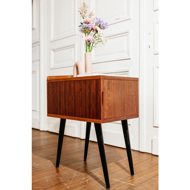 Vintage teak veneer side table on black lacquered tapered legs. This piece is in excellent vintage condition with only...