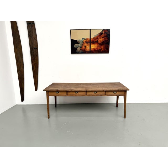 Maison Lecan presents this antique farmhouse table in beech and pine, a rare model with 8 drawers. Originally used as a...
