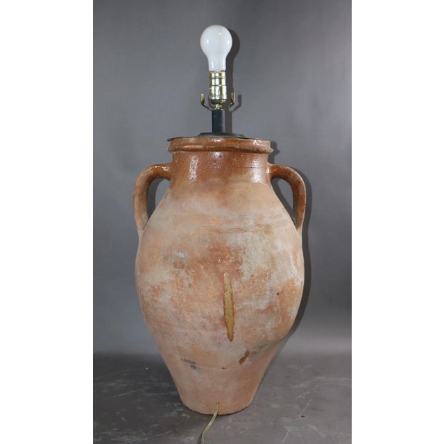 A sculptural Italian oil jar lamp with exceptional patina--where utilitarian pottery meets timeless design. Now...