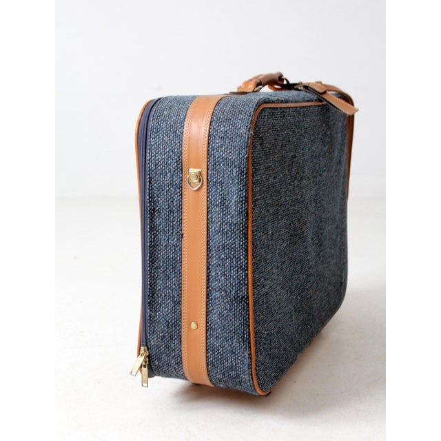 This vintage 1980s Frequent Traveler suitcase features a tailored blue-gray tweed exterior with camel-toned trim and...