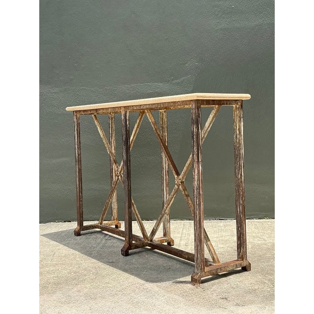This vintage console table beautifully combines the enduring strength of patinated metal with the refined elegance of a...