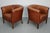This pair of cognac-colored leather club chairs come from the Netherlands. They are upholstered with patinated cognac-...