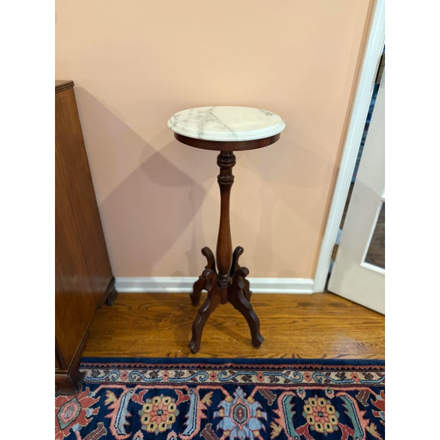 This Victorian period marble-top plant stand is a captivating example of 19th-century elegance and craftsmanship....