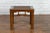A Chinese Qing Dynasty period wooden side table from the 19th century, with rattan top and pillar strut motifs. Created in...
