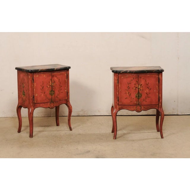 A pair of French-style raised side chests with decoratively painted wood finish and shapely bodies. This vintage pair of...