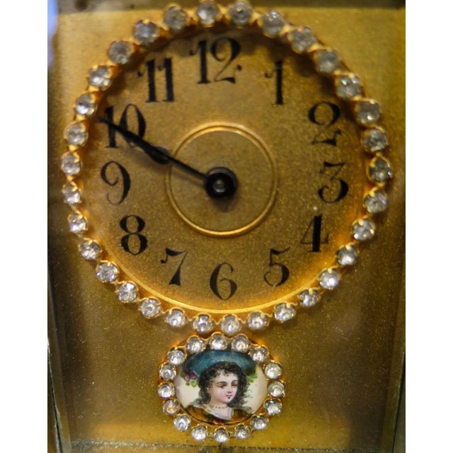 This vintage 19th century brass key wind mechanism timepiece is housed within glass panels. Looking through the front...