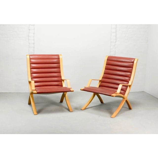 - Set of Danish beech high back AX lounge chairs - Padded red leather upholstery - Designed by Peter Hvidt and Olga...