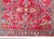 A petite early 20th century Persian Sarouk rug with a mirrored floral pattern across the field, surrounded by a simple...