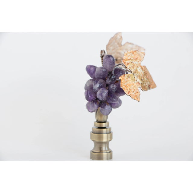 Amethyst lamp finial featuring a petite purple bunch of tumbled mineral grapes surrounded by metal leaves topping an...