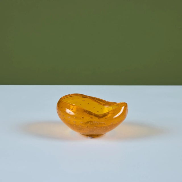 Freeform, pinched bubble glass bowl. This Murano style glass bowl features an orange bubble glass with two pinched sides....