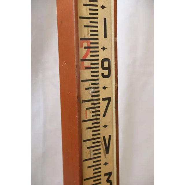 Telescoping surveyors measuring staff made of wood with brass fittings. Marked 'Houghton-Butcher Mfg. Co. Ltd., London...