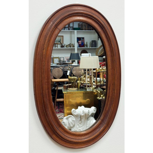 Vintage oval farmhouse style wood framed wall mirror. Features nice, rich natural wood tones with beveled frame. Natural...