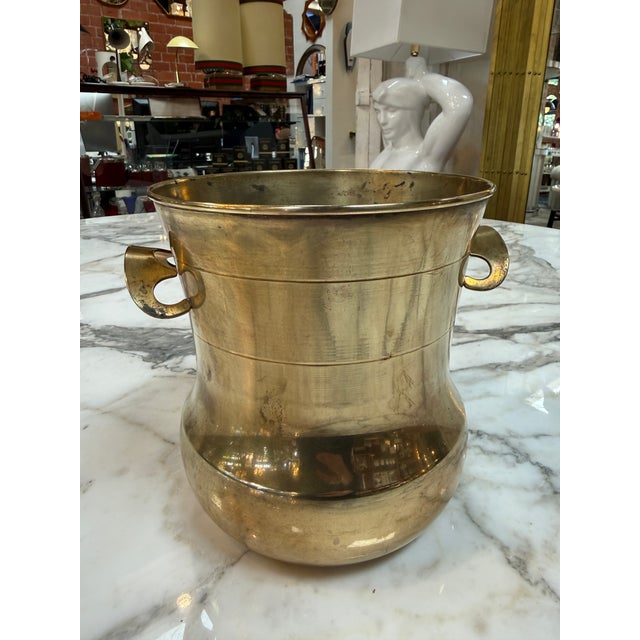 Classic vintage solid brass champagne bucket featuring a gracefully shaped body with a flared rim, rounded base, and...
