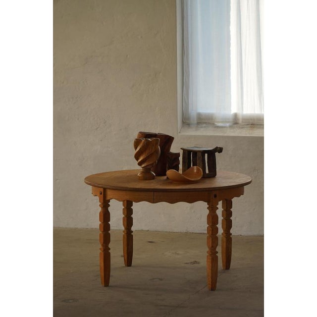 A classic round dining table crafted in solid oak, produced in the 1960s by C.J. Rosengaarden. The table features a...